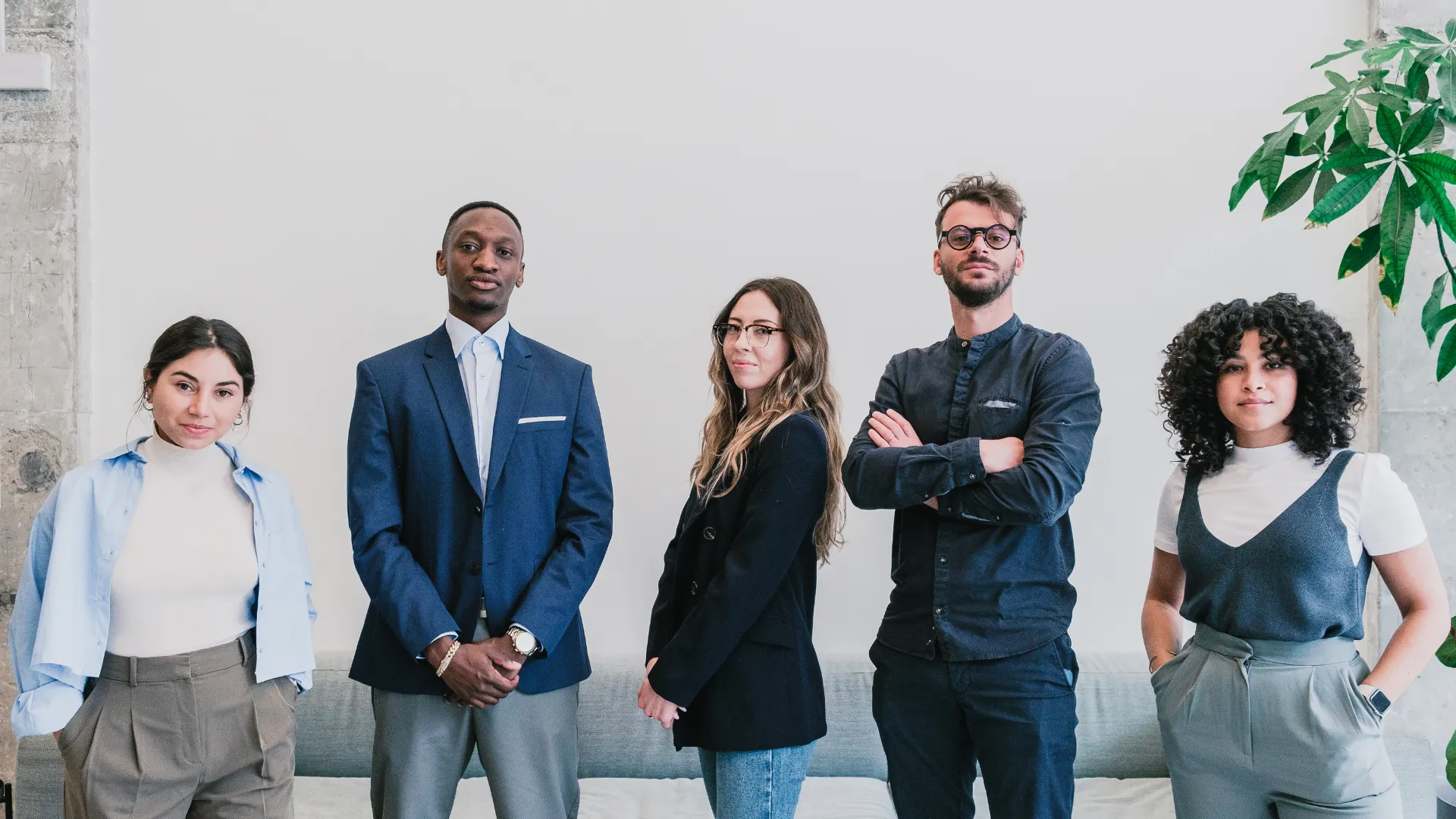 Un groupe de cinq personnes qui posent devant l'objectif